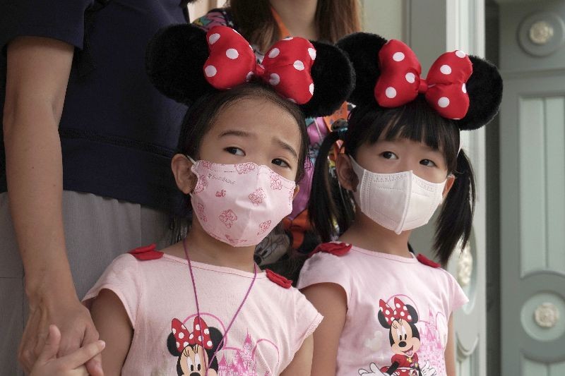 Young visitors wearing face masks look at the iconic cartoon characters Goofy and Pluto at the Hong Kong Disneyland, Friday, September 25, 2020. Hong Kong Disneyland reopened its doors to visitors after closed temporarily due to the coronavirus outbreak. (Photo by Kin Cheung/AP Photo)